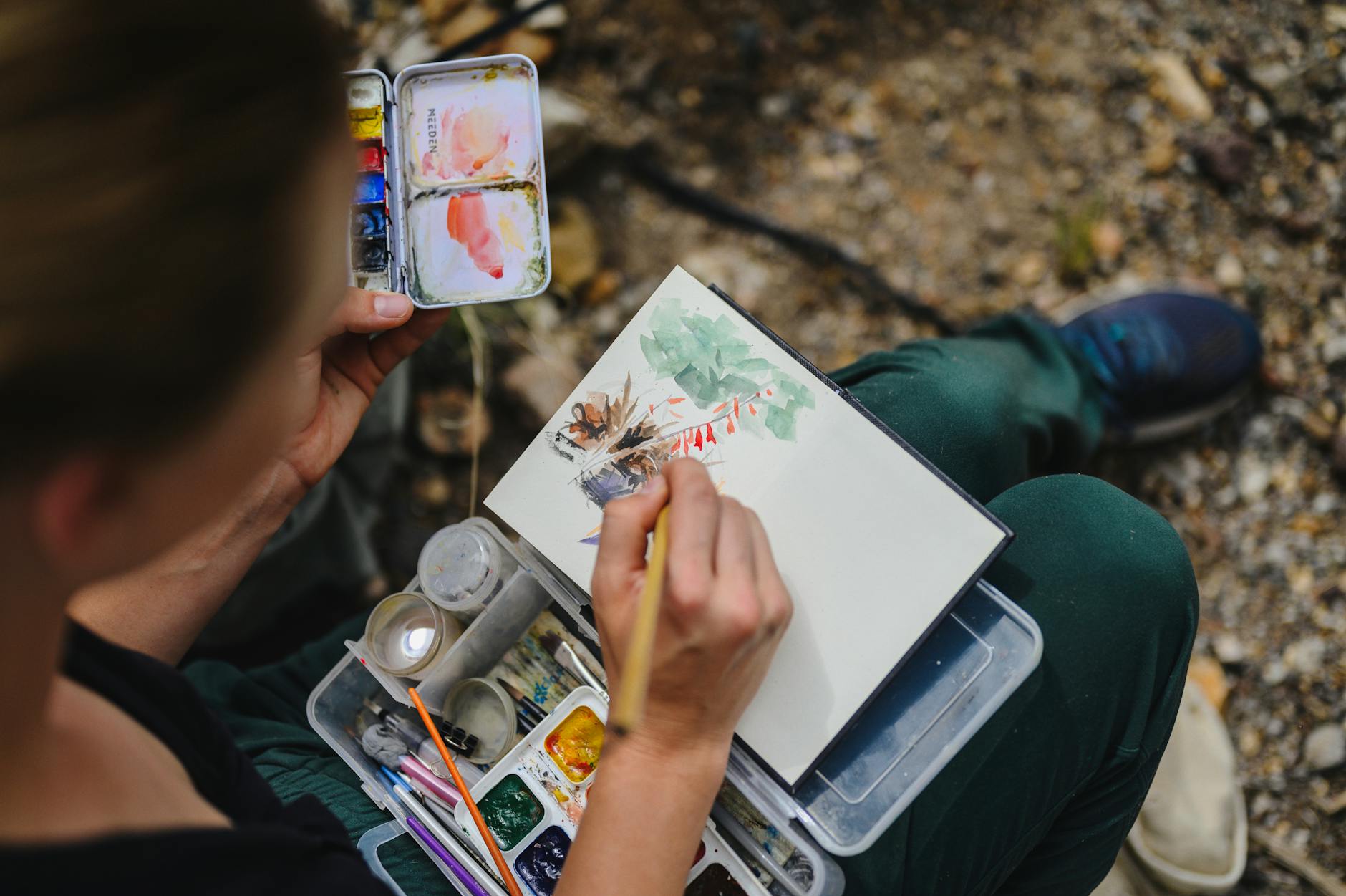 close up shot of a woman painting on a notebook